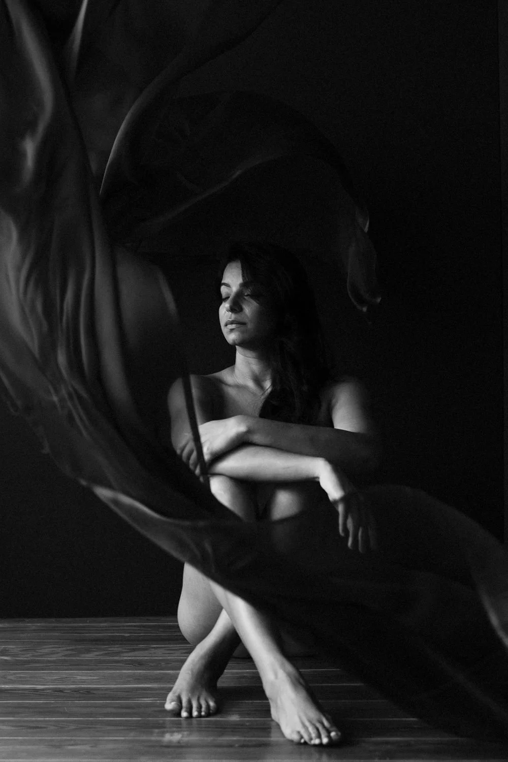 woman sitting down with material dropped over her during a boudoir session in Barbados. Photo by Aniya Emtage