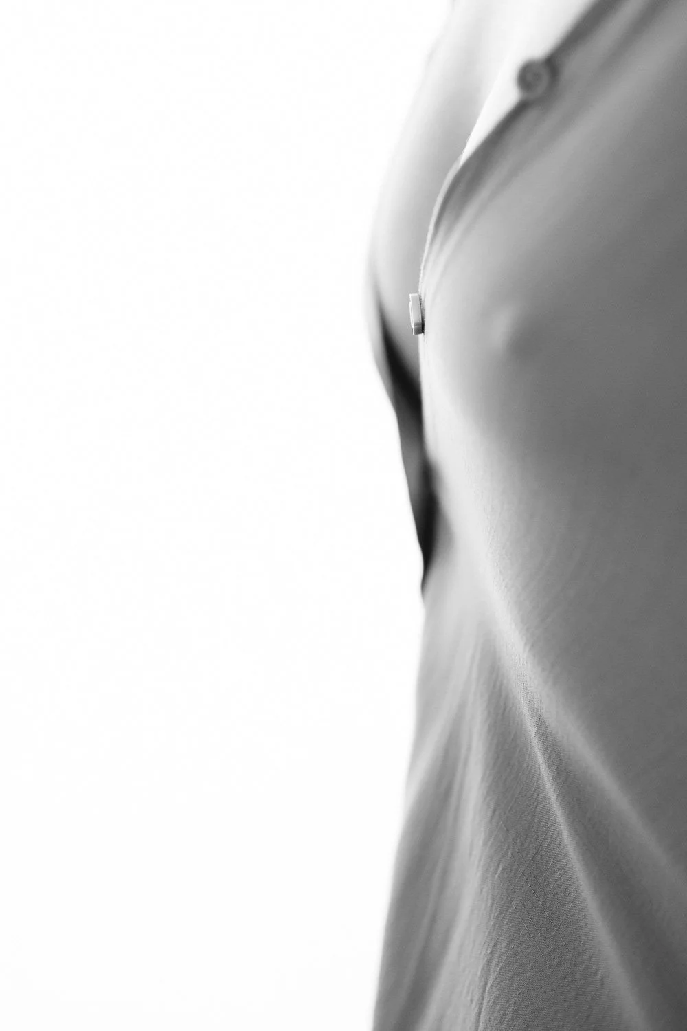Close-up black and white photo of a tailored suit jacket from a side angle.