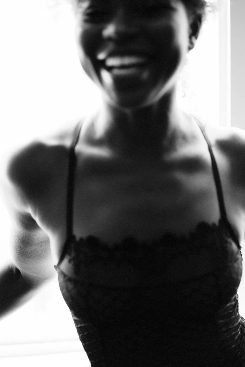Smiling woman in lace dress, black and white photo, close-up shot.