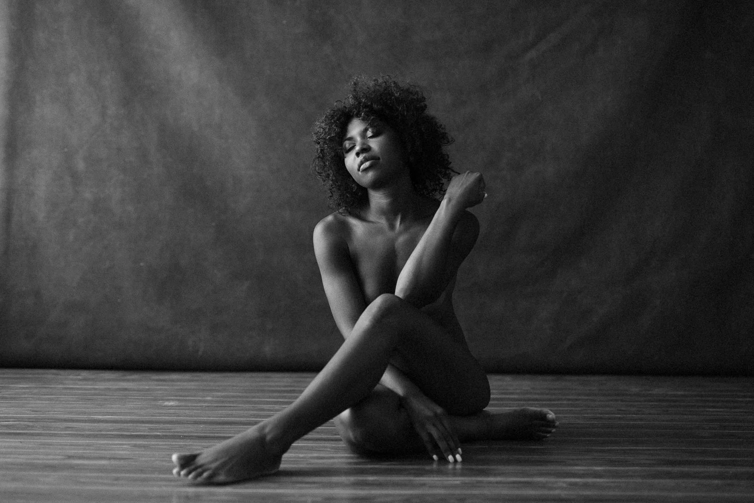 woman sitting for an implied nude during a boudoir session in Barbados. Photo by Aniya Emtage