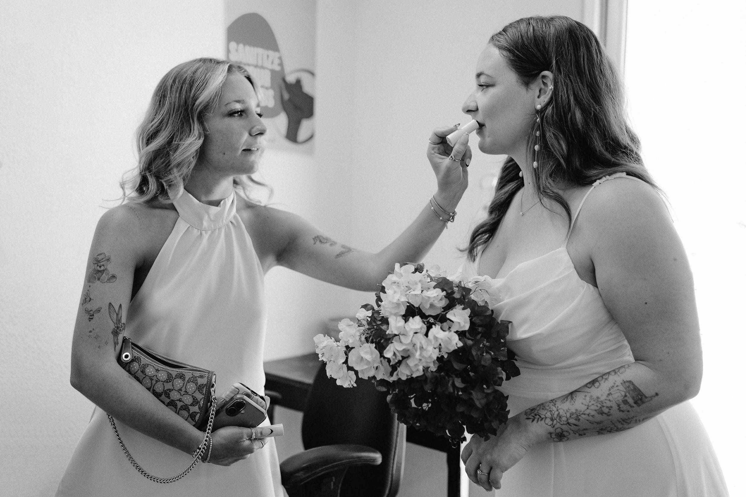 bride's sister putting lipstick on her after her barbados courthouse wedding