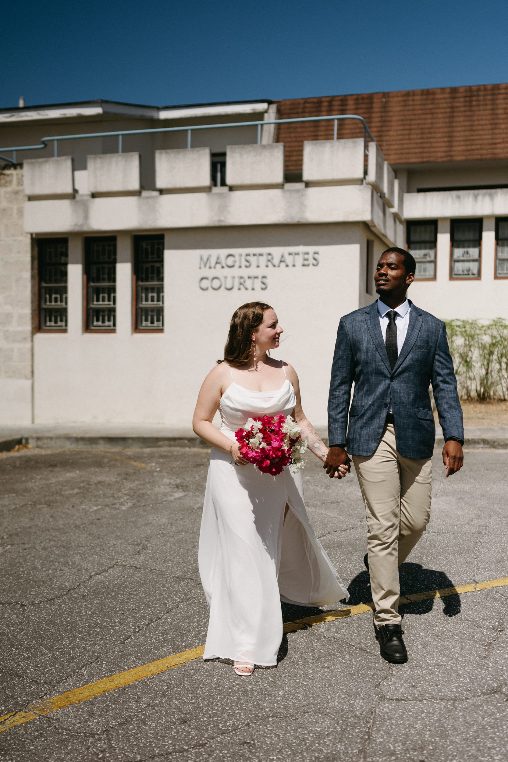 Happy couple walking holding hands after their barbados courthouse wedding