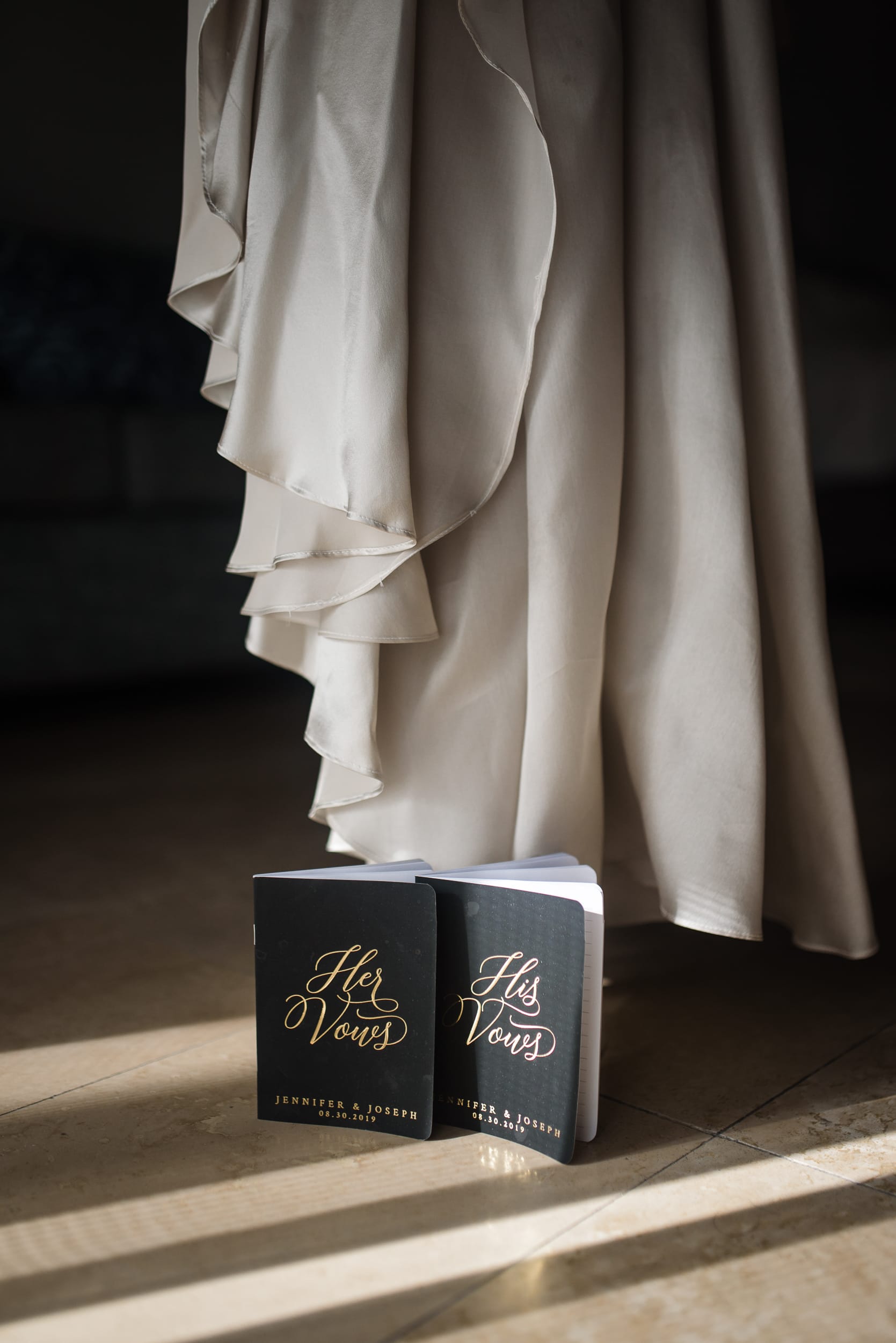 two vow books next to the wedding dress