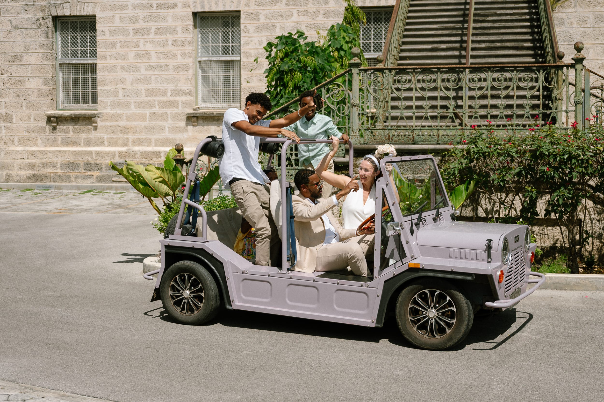 family in a mini moke after their barbados courthouse ceremony