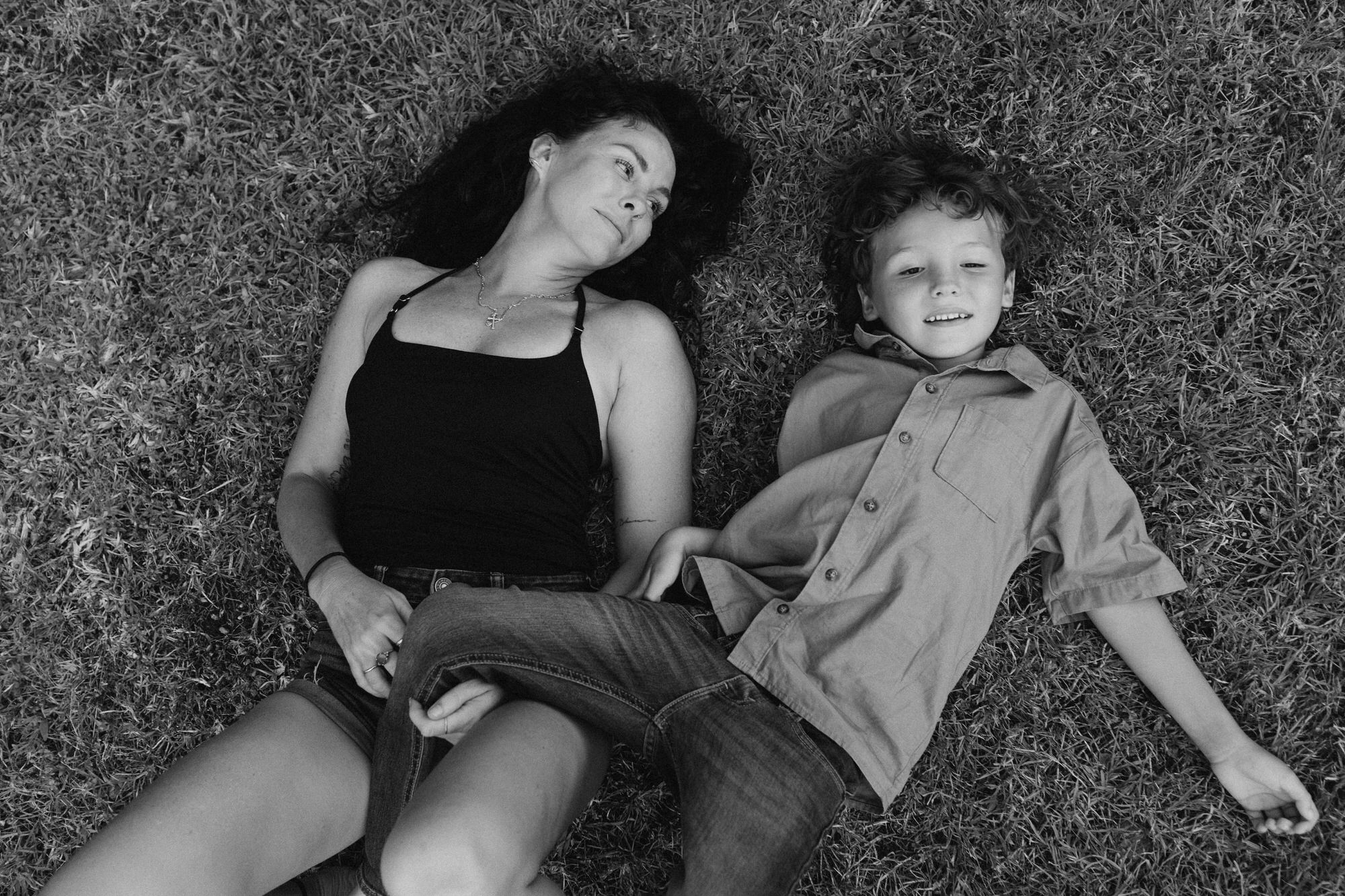mom lying down with son on the grass