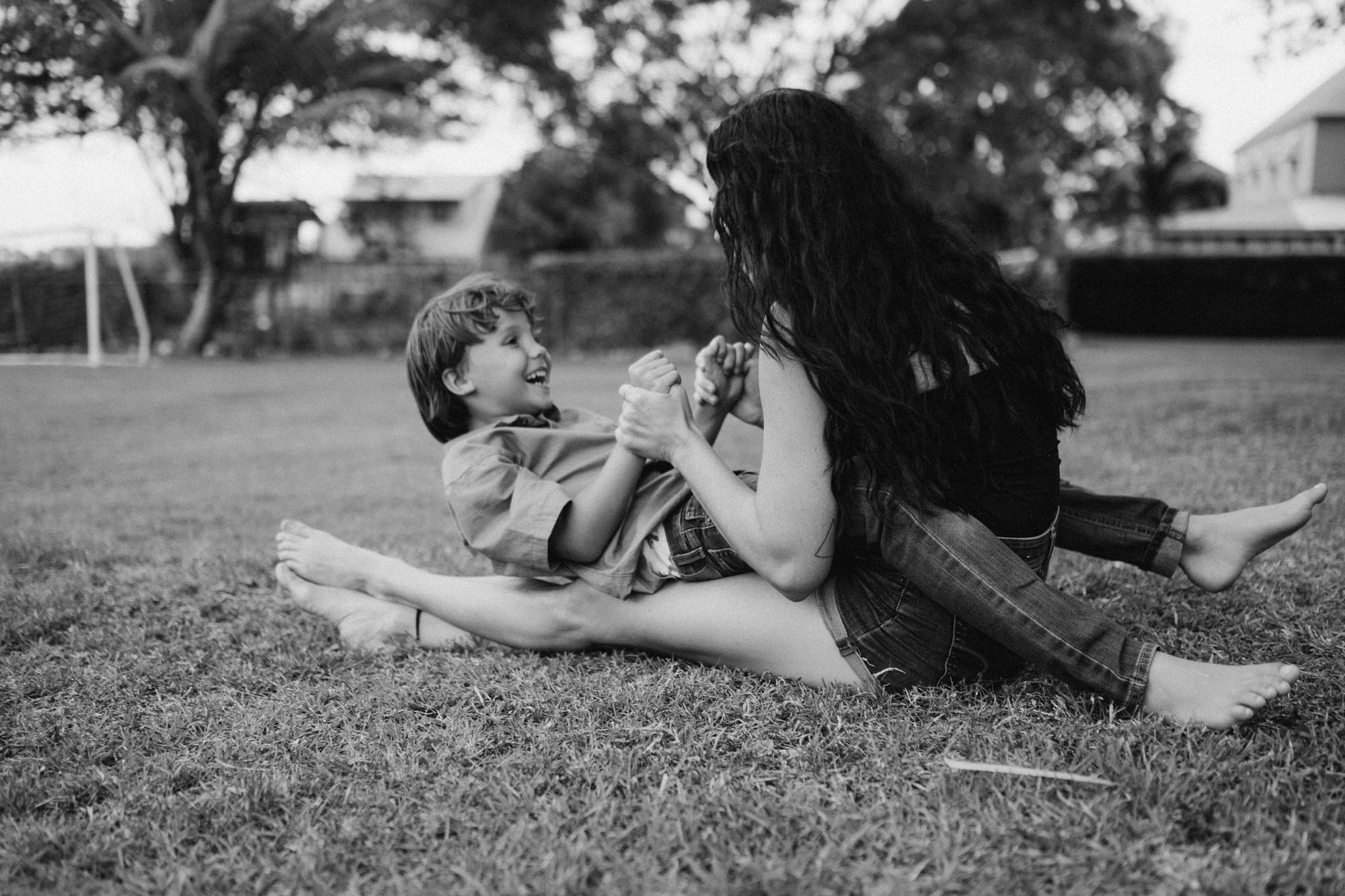mom playing with son on the grass