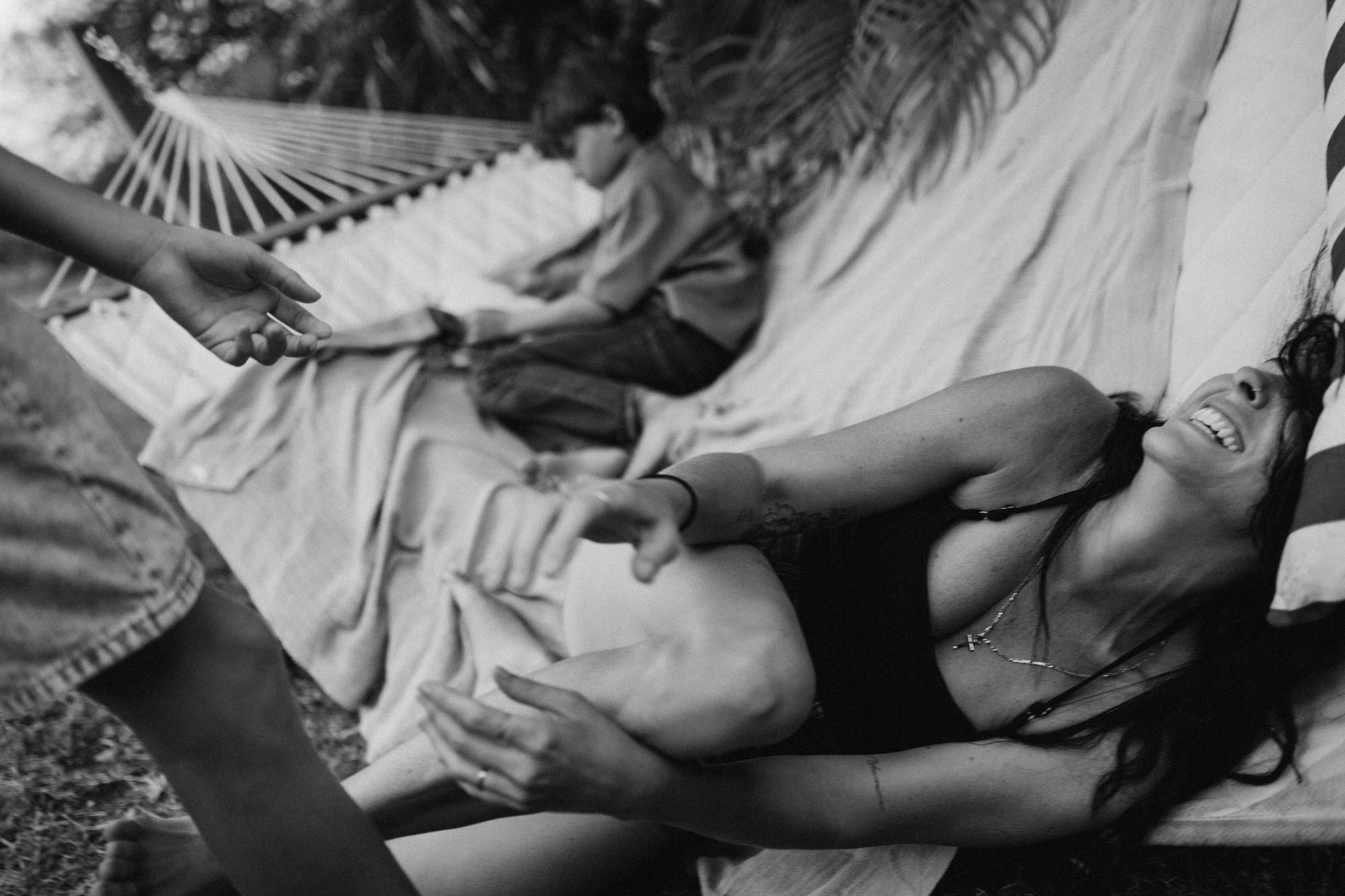 mom laughing out loud with son in hammock