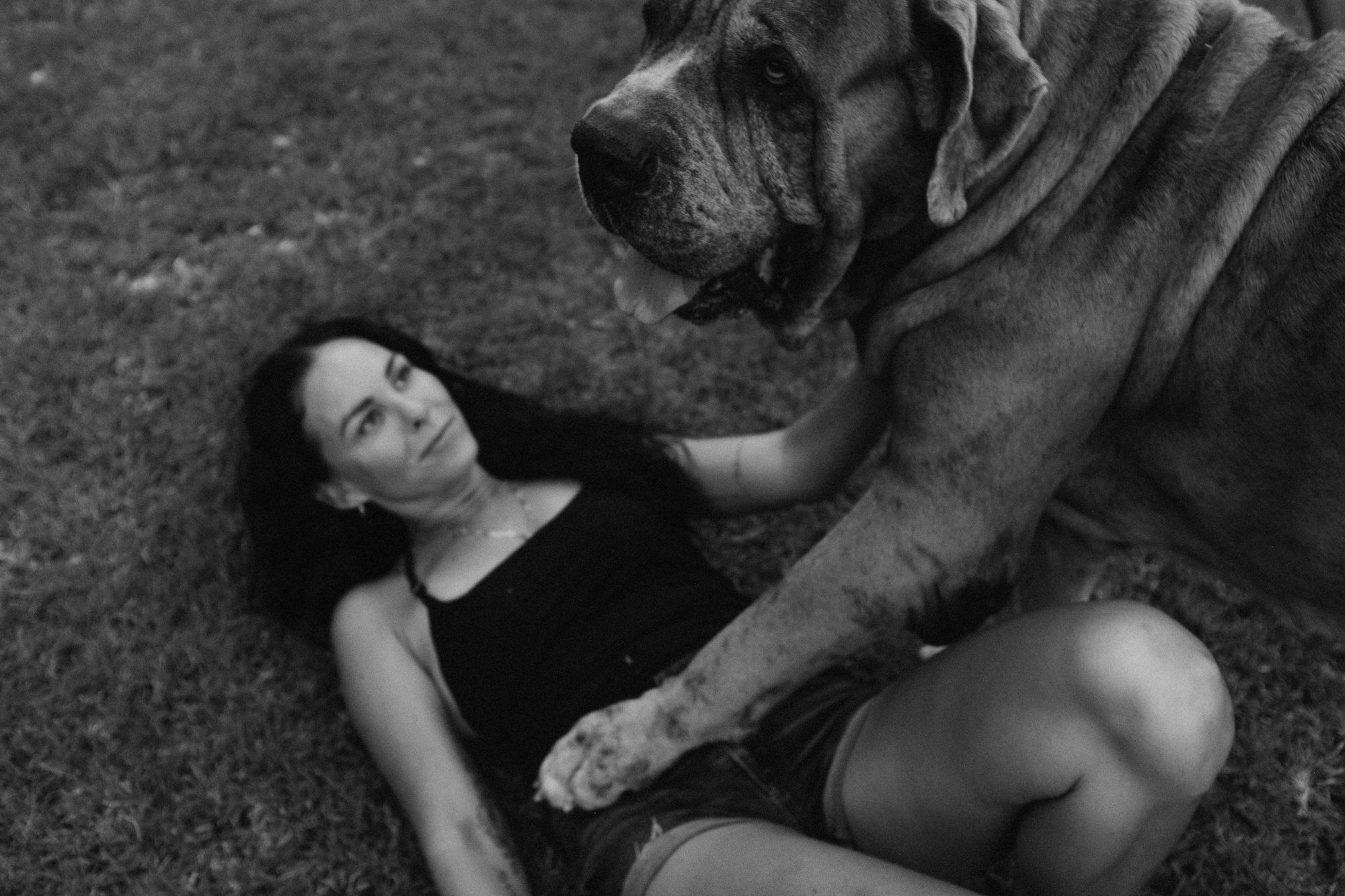 mom lying in the grass looking up at her dog